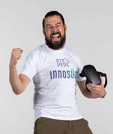 Jan Fiedler hält eine Virtual Reality Brille in der Hand und ballt die Faust begeistert zusammen
